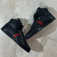 GUCCI 2010年代アーカイブの黒レザーハイカットスニーカー。サイドに赤と緑のウェブストライプ（シェリーライン）を配したミニマルなデザイン。