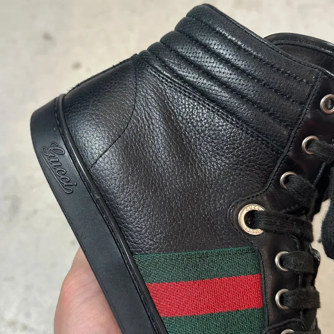 GUCCI 2010年代アーカイブの黒レザーハイカットスニーカー。サイドに赤と緑のウェブストライプ（シェリーライン）を配したミニマルなデザイン。