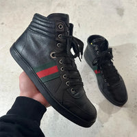 GUCCI 2010年代アーカイブの黒レザーハイカットスニーカー。サイドに赤と緑のウェブストライプ（シェリーライン）を配したミニマルなデザイン。